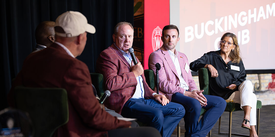 Men’s basketball coach Greg Gard shares the stage with fellow panelists Chris Solinsky, Robin Pingeton, and Corey Pompey (left, obscured) while Jeff Wendorf ’82 moderates.